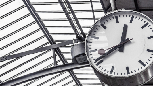 Black and gray photo of a big clock in a station