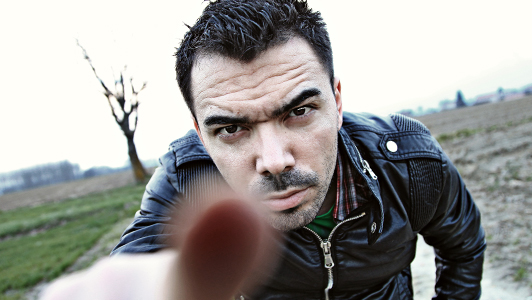 A guy with a frowny face pointing with his finger.