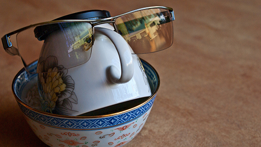 A bowl, a cup, and glasses shaping a head.