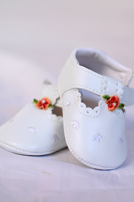 White baby shows with a flower ornament.