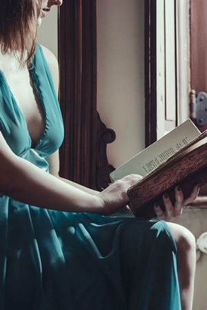 woman in green dress with open book