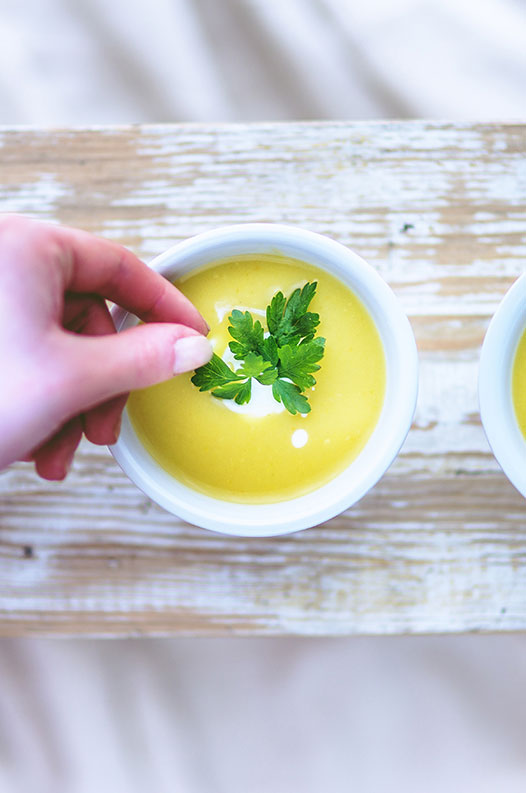 A bowl of cream soup on a rustic surface.