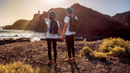 couple holding hands overlooking shore