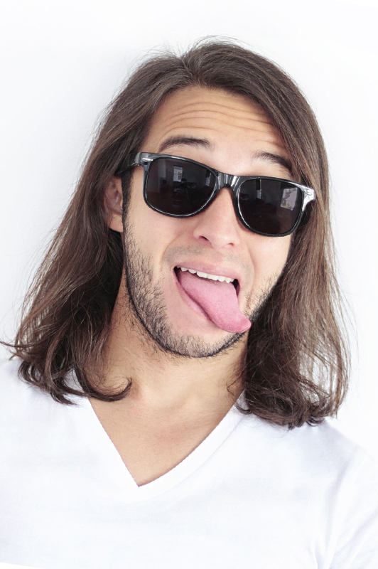 A guy with long hair sticking his tongue out.