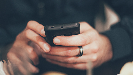 Guy in a black shirt texting.