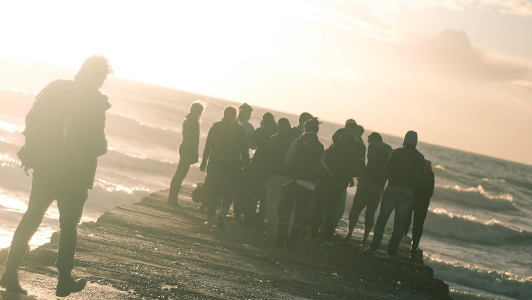 A group of people looking at sea.