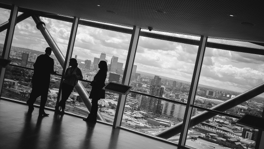 A man talking to two women in a skyscraper.