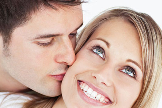 happy woman being kissed getting along with boyfriend