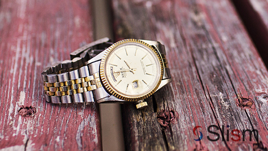 A wrist watch on a wooden board