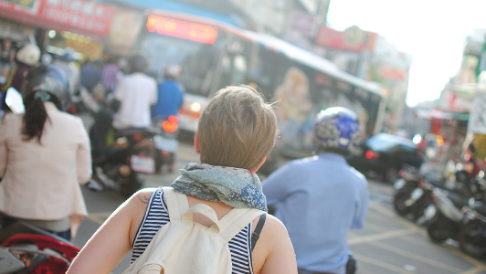 Girl with short hair carrying backpack on her back