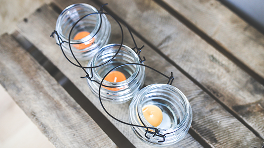 Three tea light candles in glass jars