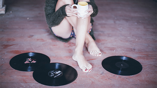 girl sitting surrounded with vinyls