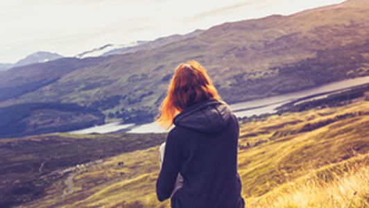 woman sitting on hill thinking