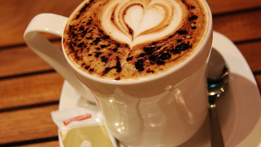 A cup of coffee with heart shapes in the foam.