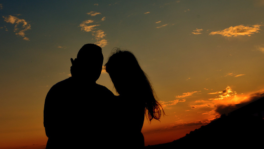 Silouette of a couple standing in the sunset