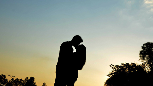 Couple kissing in the sunrise.