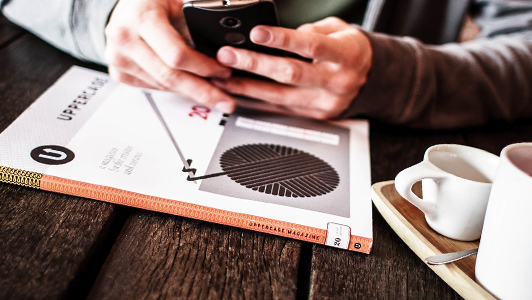 Guy with a book texting.