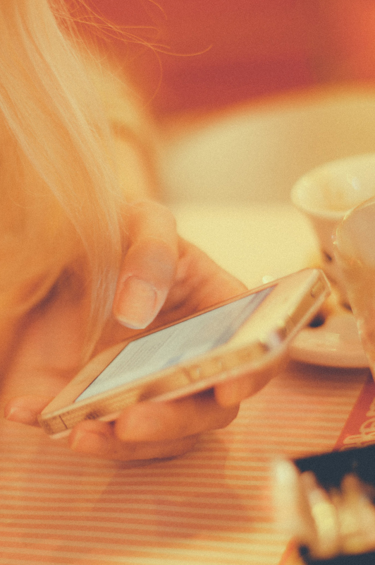 Girl with blonde hair texting.