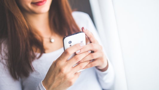 Girl in white blouse texting.