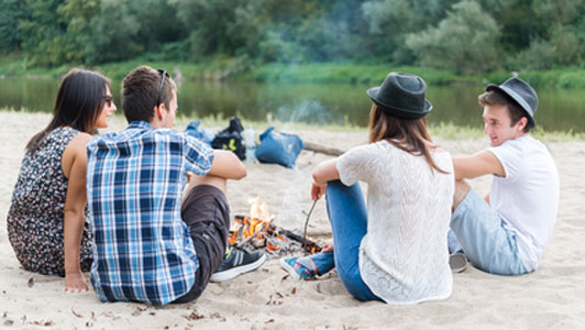 friends sitting around bonfire