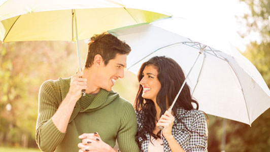 man holding umbrella over woman with umbrella