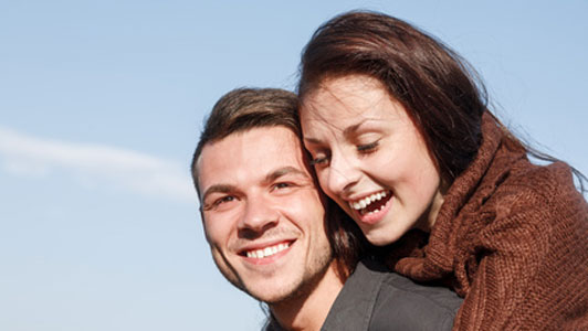 man giving woman piggy back ride