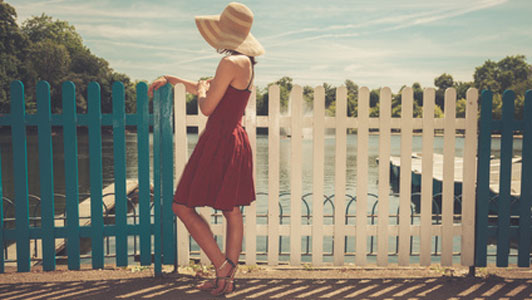 woman standing by blue and white fence