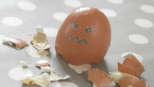 Broken egg shell with an angry face drawn on it.