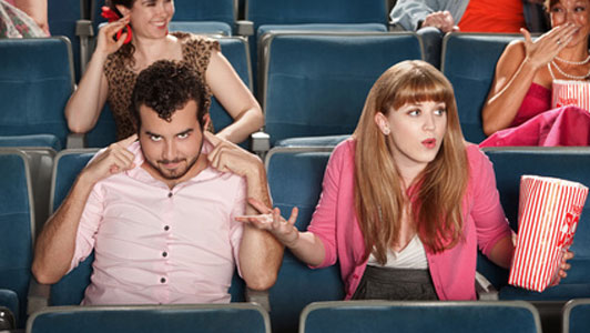 couple in movie theatre man not listening woman frustrated