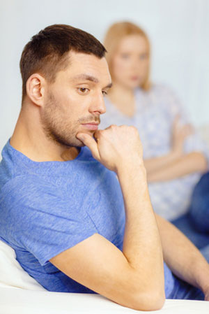 man on couch with woman in background