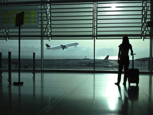 woman with baggage overseeing plane taking off