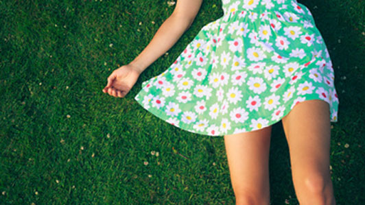 girl in green dress laying down on grass