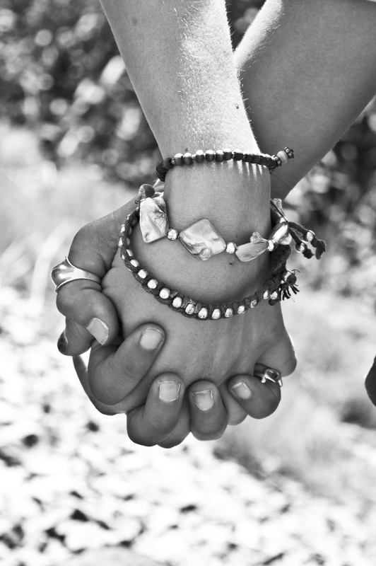 Black and gray photo of a couple's fingers being interlocked 