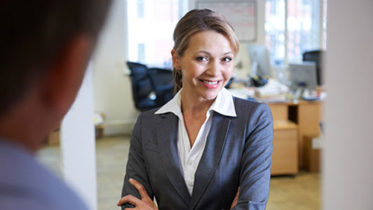 smiling woman with arms crossed standing in front of guy