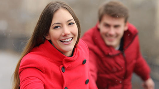 woman in red being playfuly chased by man in red