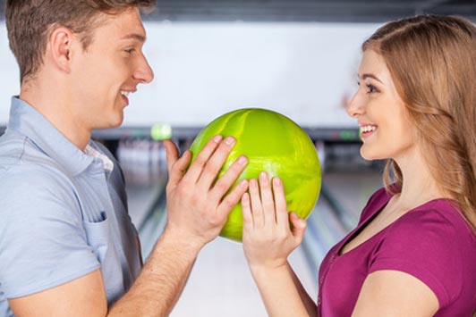 man and woman holding bowling ball on date