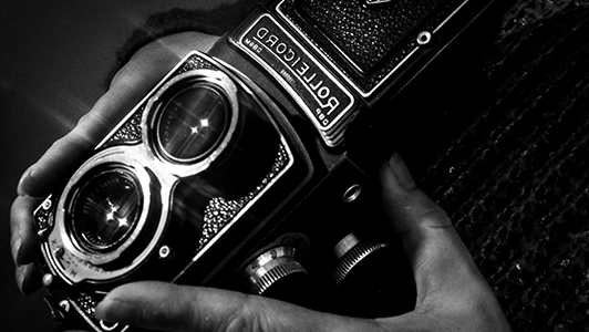 Hands hoding a vintage camera.