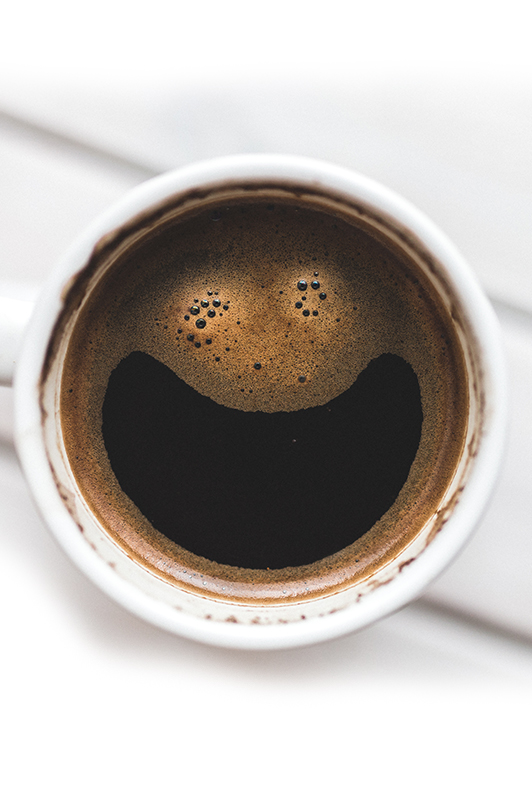 A smiley face in a cup of cofee