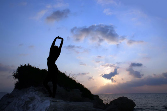 girl stretching overlooking ocean