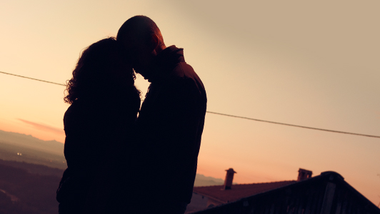 Silhouette of a couple kissing.