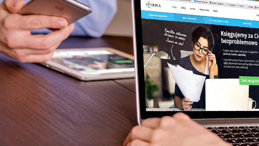 girl sitting in front of a laptop while a guy is looking at his iphone