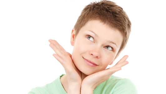 Woman smiling and holding palms against her cheeks