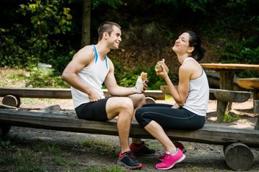 happy couple eating together in park