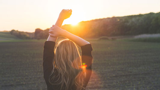 light shining upon woman in view of open field outdoors