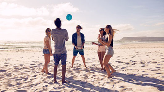 group of friends playing beach ball in a circle