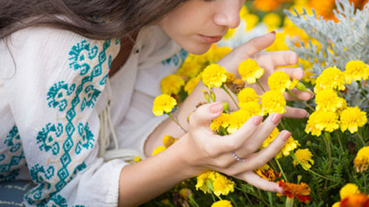 young woman smelling yellow flowers