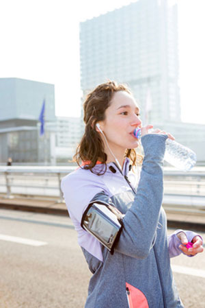 woman out jogging drinking bottled water