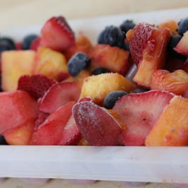 A tray with frozen strawberries and other fruit.