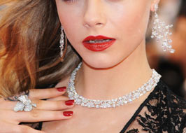 Girl wearing expensive jewelry and read lipstick.