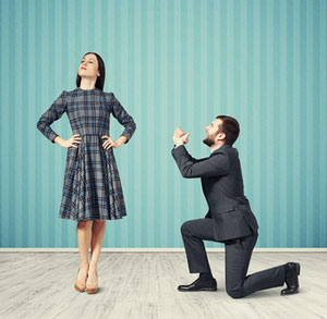 man on knees asking stubborn woman